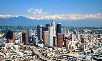 Los Angeles skyline with snow-capped mountains in the background.