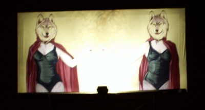 Billboard with two women in swimsuits and red capes with wolf heads. WTF?